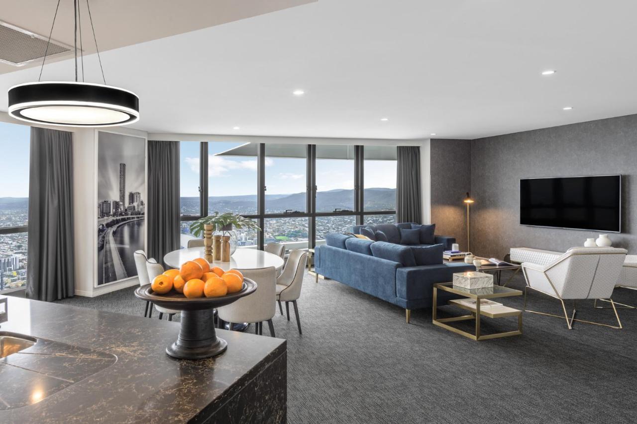 赫歇尔街美利通套房酒店 布里斯班 外观 照片 The photo depicts a modern and stylish living space, likely a living room or open-concept apartment. Key features include:

- **Large Windows:** Expansive windows offering a view of the outdoors, possibly a cityscape or landscape.
- **Furniture:** A 
